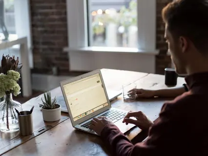 Homem com notebook e computador no escritório