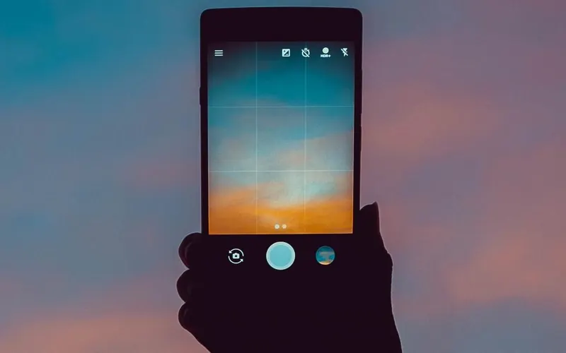 Mãos com celular e câmera