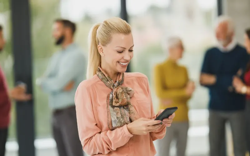 Mulher com celular no escritório